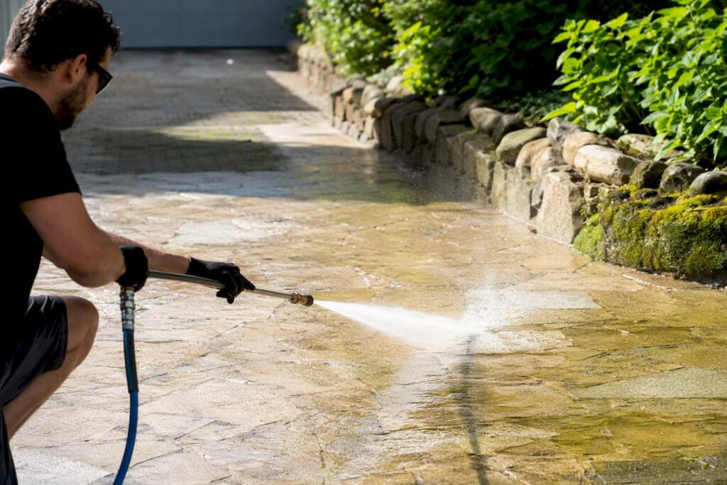 Technician softwashing algae on UK driveway